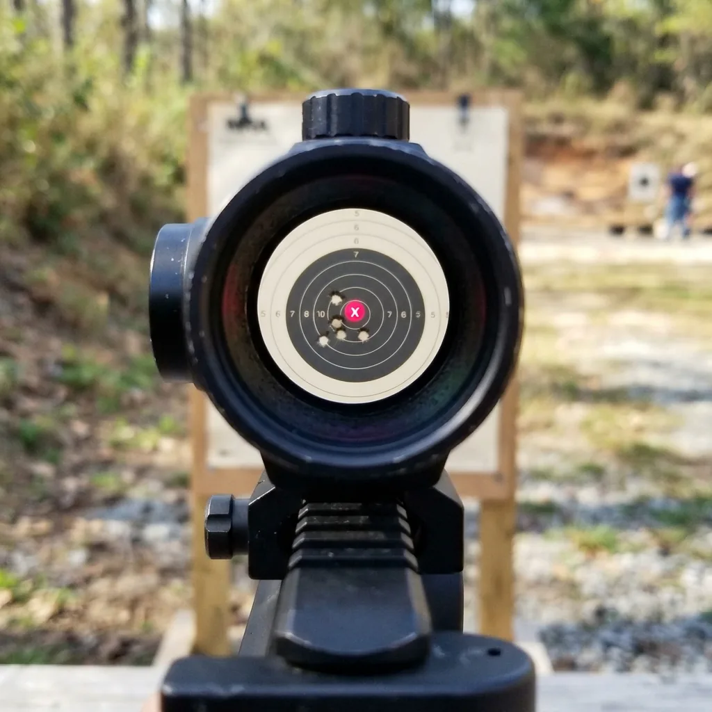 A view through the Simmons red dot sight, showing the illuminated dot aligned with a distant target.